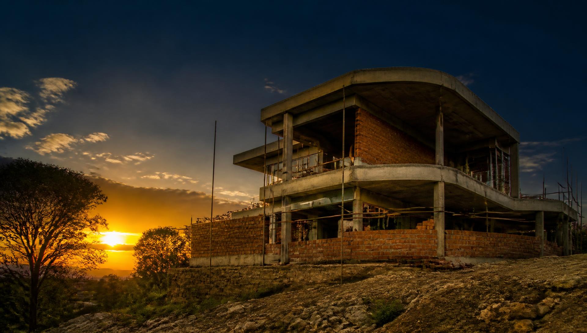 Sunset over a house under construction on a hill outside Harare
